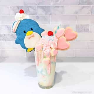 Let's celebrate our Friend of the Month with a yummy milkshake topped with an adorable ice cream cookie sandwich inspired by #Tuxedosam! 🐧💙🍦 It's the perfect summer treat! Visit the link in bio for the step-by-step recipe by @k8oleary22✨ #SanrioFOTM